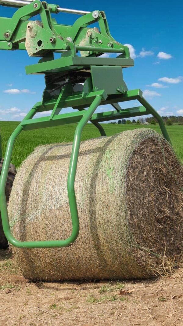 big bale grabber lifting a large hay bale